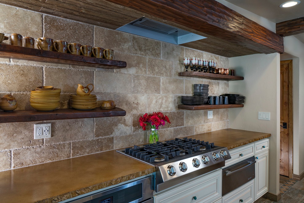 Eat-in kitchen - mid-sized rustic single-wall porcelain tile eat-in kitchen idea in Phoenix with a farmhouse sink, raised-panel cabinets, white cabinets, concrete countertops, beige backsplash, stone tile backsplash, stainless steel appliances and two islands
