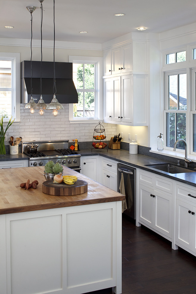 This is an example of a traditional kitchen in San Francisco with stainless steel appliances, subway tile splashback, wood benchtops and white cabinets.