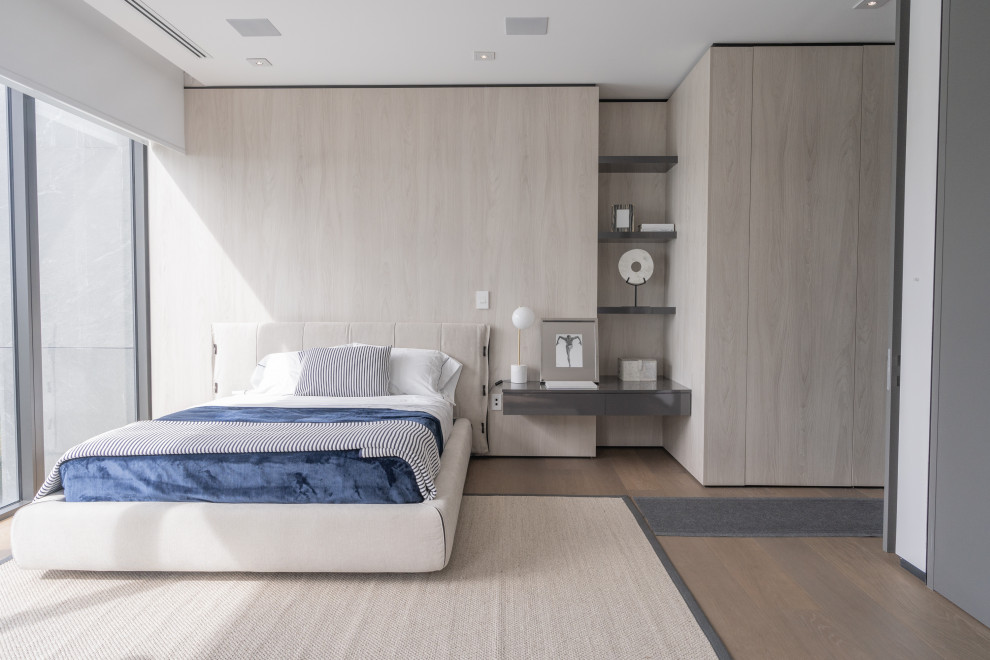 Design ideas for a contemporary bedroom in Miami with beige walls, medium hardwood floors, beige floor and wood walls.