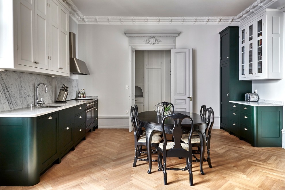 Photo of a large traditional galley eat-in kitchen in Stockholm with marble benchtops, grey splashback, a single-bowl sink, raised-panel cabinets, green cabinets, coloured appliances, light hardwood floors and no island.