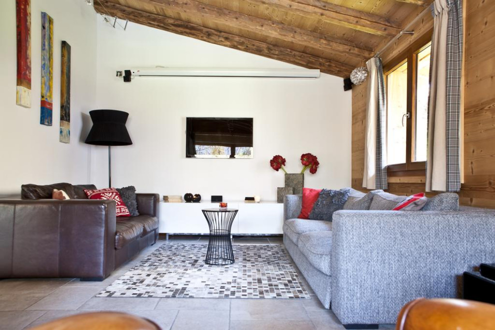 This is an example of a large farmhouse living room with a timber clad chimney breast, a wall mounted tv, a wood ceiling and wood walls.