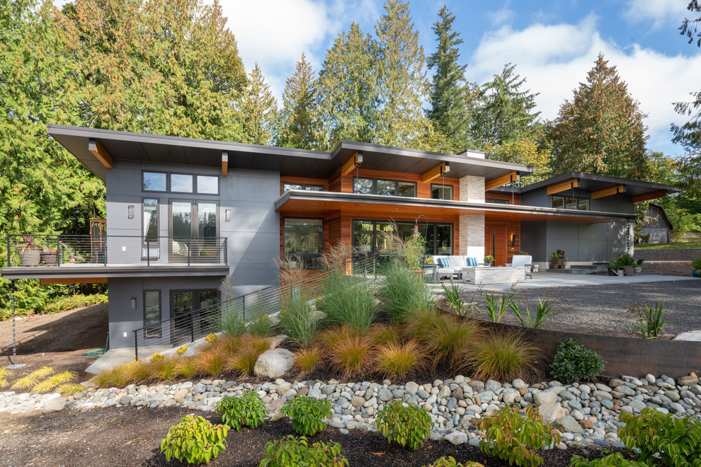 Contemporary two-storey blue house exterior in Seattle with concrete fiberboard siding, a shed roof and a metal roof.