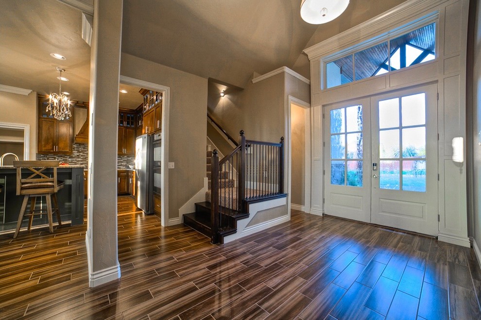 This is an example of a mid-sized transitional front door in Oklahoma City with beige walls, vinyl floors, a double front door and a white front door.