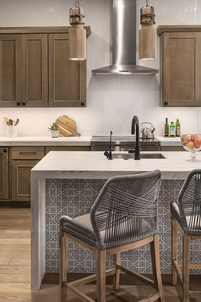 Open concept kitchen - mid-sized transitional l-shaped medium tone wood floor and brown floor open concept kitchen idea in Phoenix with recessed-panel cabinets, marble countertops, white backsplash, an undermount sink, medium tone wood cabinets, ceramic backsplash, stainless steel appliances and an island