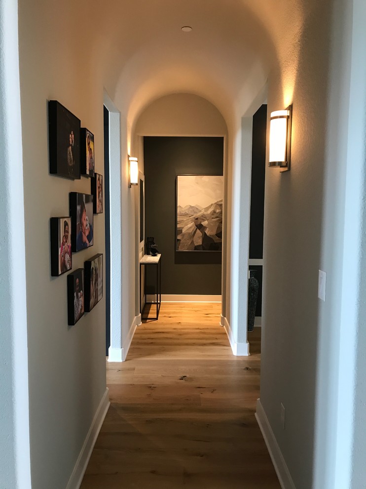 Photo of a mid-sized contemporary hallway in Dallas with grey walls, light hardwood floors and beige floor.