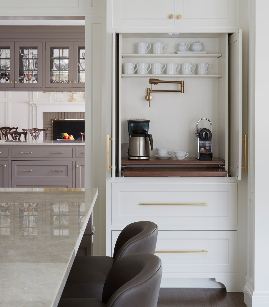 Inspiration for a large transitional l-shaped open plan kitchen in Chicago with an undermount sink, recessed-panel cabinets, white cabinets, marble benchtops, white splashback, ceramic splashback, stainless steel appliances, medium hardwood floors, with island, brown floor and beige benchtop.