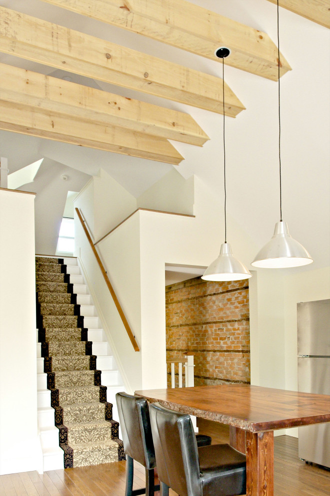 Kleines Rustikales Wohnzimmer im Loft-Stil mit weißer Wandfarbe, braunem Holzboden, freistehendem TV, braunem Boden, freigelegten Dachbalken und Ziegelwänden in Sonstige