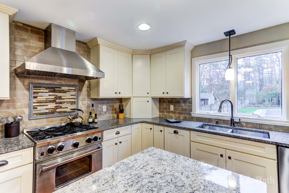 Example of a large transitional u-shaped light wood floor eat-in kitchen design in Providence with an undermount sink, shaker cabinets, beige cabinets, granite countertops, brown backsplash, porcelain backsplash, stainless steel appliances and an island