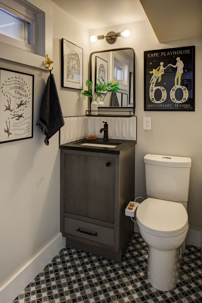 Idée de décoration pour un petit WC et toilettes bohème avec un placard à porte plane, des portes de placard grises, un mur gris, un sol en carrelage de porcelaine, un lavabo encastré, un plan de toilette en quartz modifié, un sol multicolore, un plan de toilette noir et meuble-lavabo encastré.