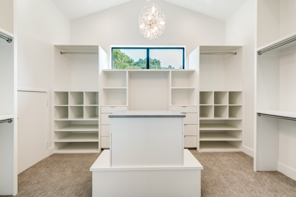 Photo of a large contemporary gender-neutral walk-in wardrobe in Dallas with flat-panel cabinets, white cabinets, carpet, grey floor and vaulted.