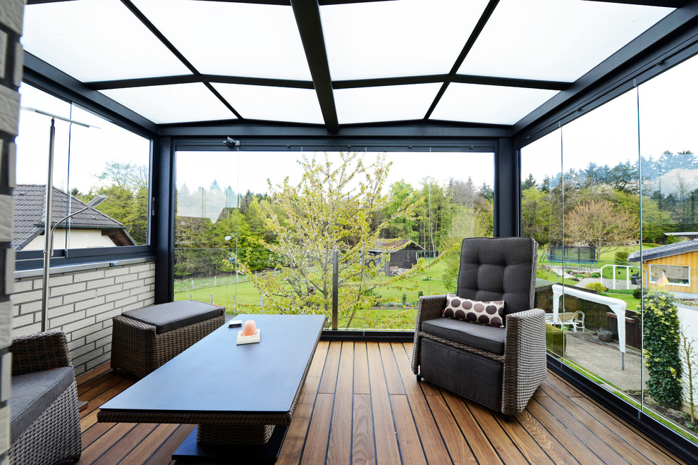 Mittelgroßer Moderner Wintergarten mit dunklem Holzboden, Kaminofen und Glasdecke in Dortmund