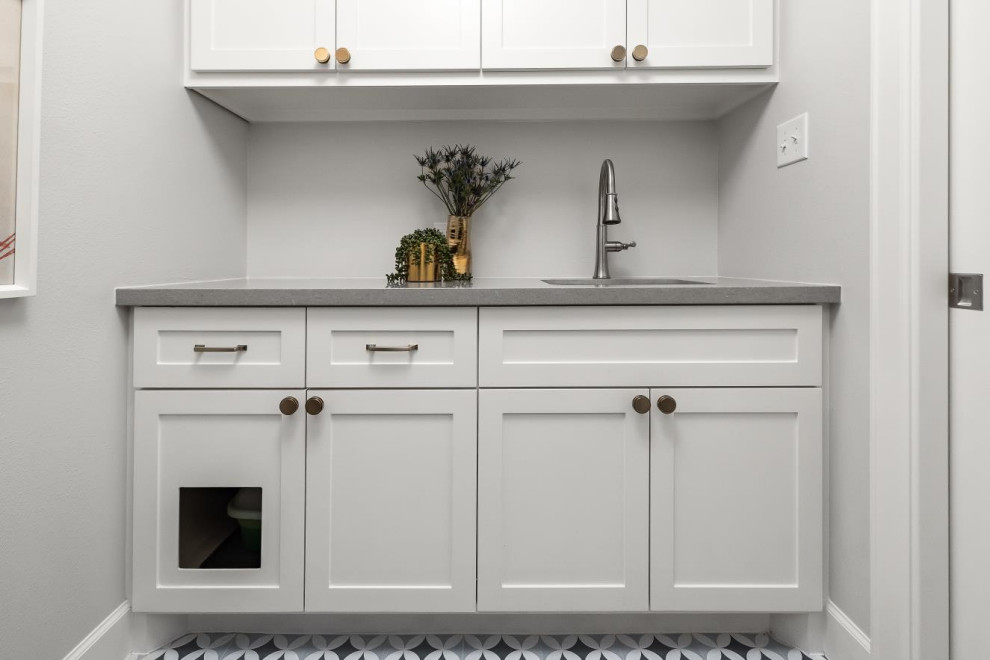 Photo of a mid-sized transitional dedicated laundry room in Houston with an undermount sink, white cabinets, granite benchtops, white splashback, ceramic splashback, grey walls, ceramic floors, a side-by-side washer and dryer and multi-coloured floor.