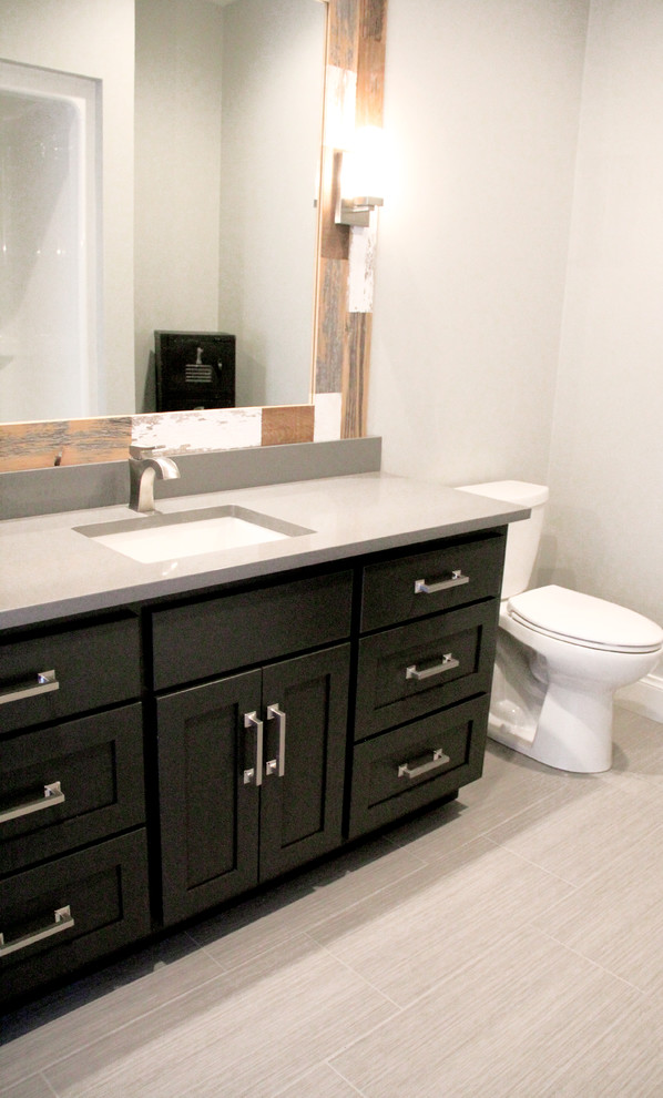 Mid-sized 3/4 brown tile and porcelain tile porcelain tile and beige floor bathroom photo with flat-panel cabinets, black cabinets, gray walls, an undermount sink and granite countertops