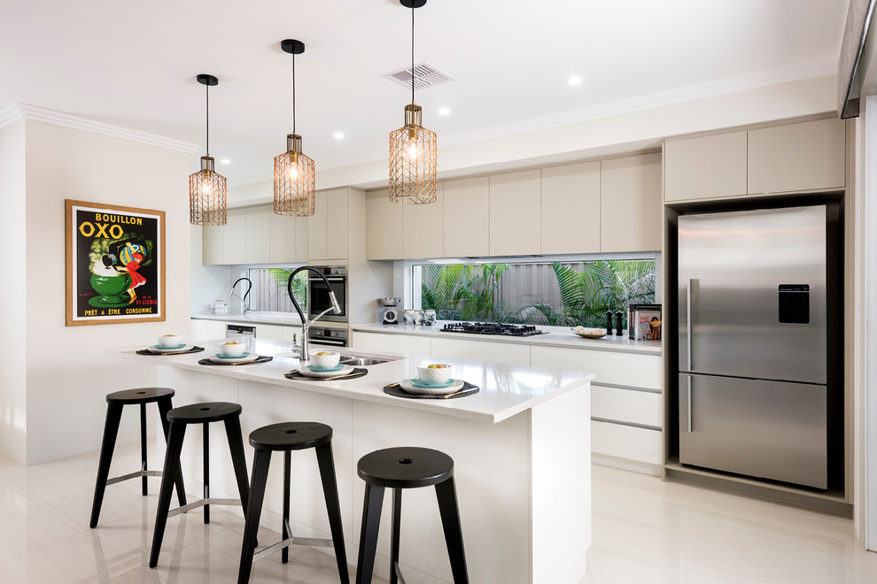 Inspiration for a large contemporary galley open plan kitchen in Perth with a double-bowl sink, flat-panel cabinets, beige cabinets, quartz benchtops, glass sheet splashback, stainless steel appliances, porcelain floors, with island and beige floor.