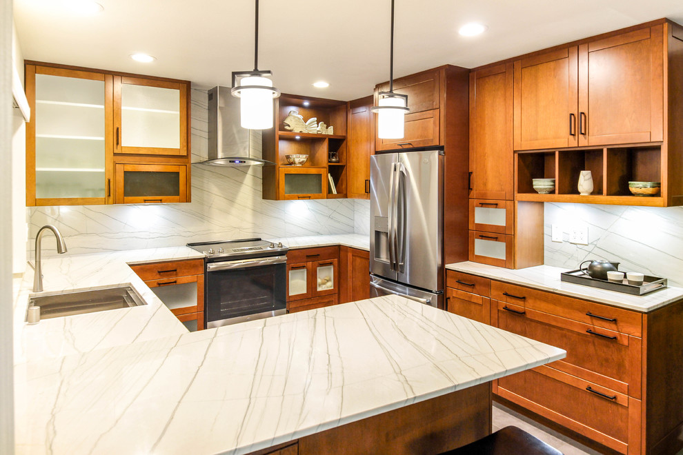 Photo of a mid-sized modern u-shaped eat-in kitchen in San Diego with a single-bowl sink, recessed-panel cabinets, medium wood cabinets, quartzite benchtops, white splashback, stone slab splashback, stainless steel appliances, cement tiles, a peninsula, grey floor and white benchtop.