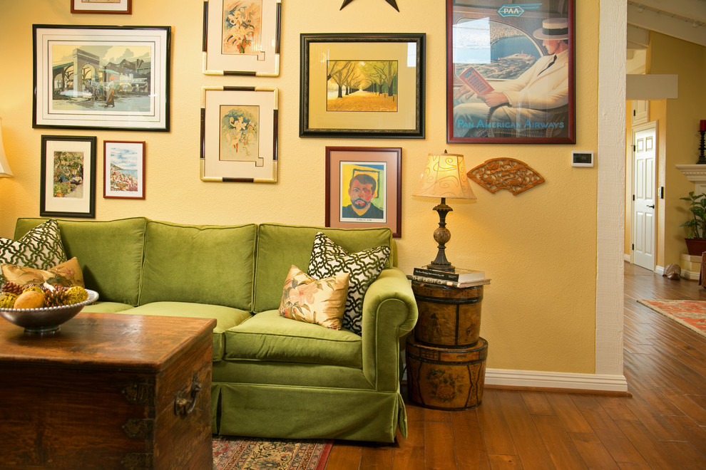 Inspiration for a mid-sized eclectic formal loft-style living room in Los Angeles with yellow walls, medium hardwood floors, no fireplace, no tv and brown floor.