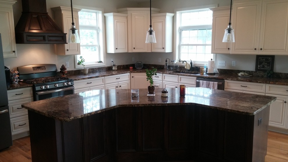 Large transitional l-shaped dark wood floor and brown floor eat-in kitchen photo with an undermount sink, raised-panel cabinets, white cabinets, granite countertops, black appliances and an island