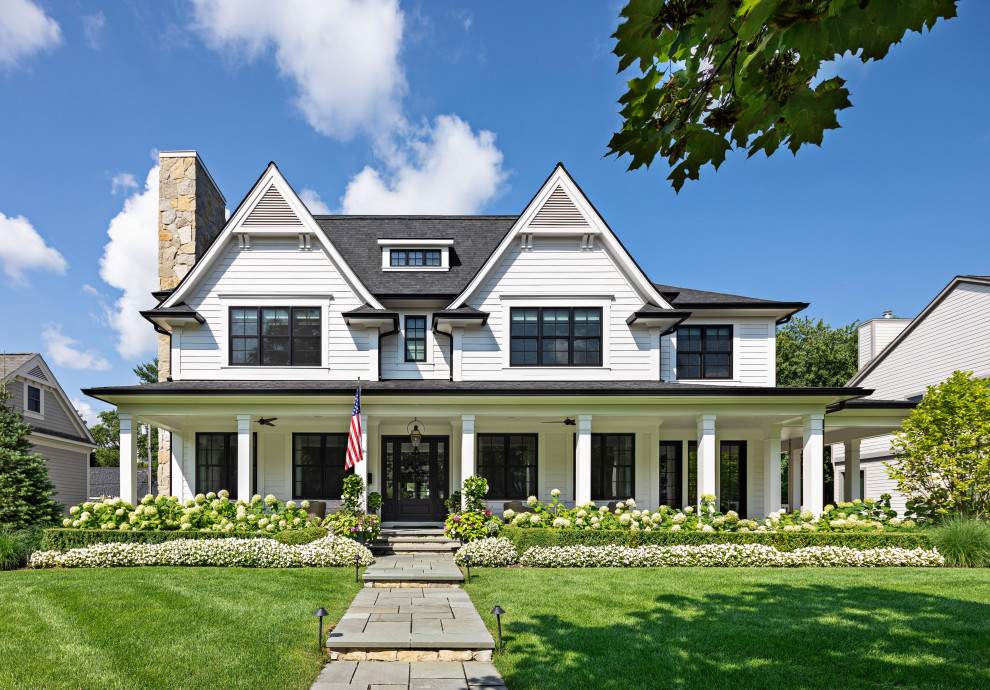 Photo of a mid-sized country two-storey white house exterior in Detroit with a hip roof and a shingle roof.