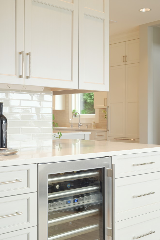 Transitional ceramic tile kitchen photo in Seattle with shaker cabinets, white cabinets, quartzite countertops, subway tile backsplash, stainless steel appliances, an island and white countertops