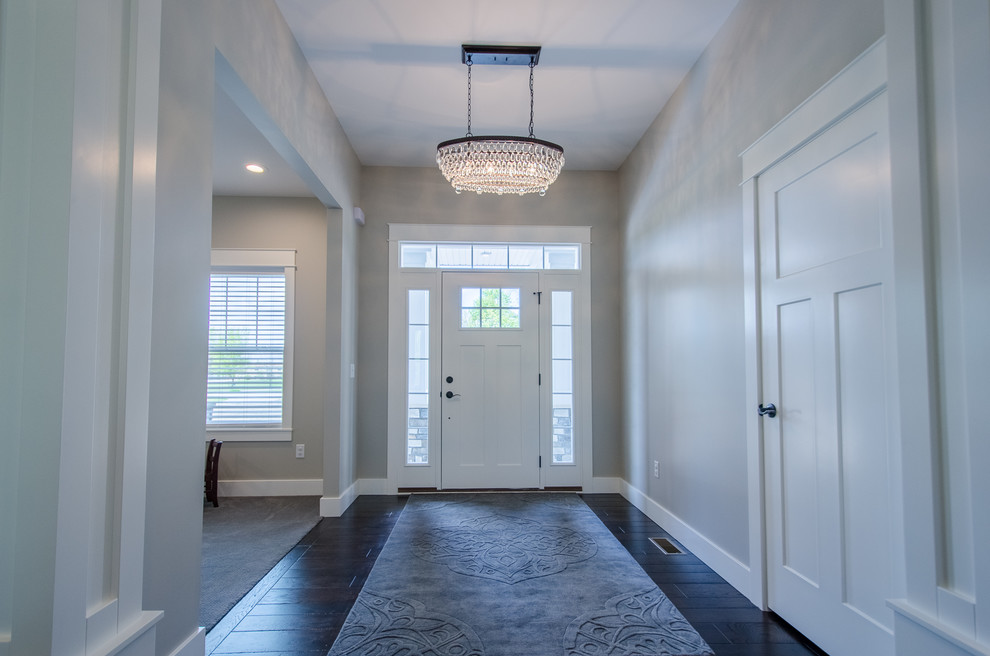 Mid-sized transitional dark wood floor mudroom photo with gray walls and a white front door