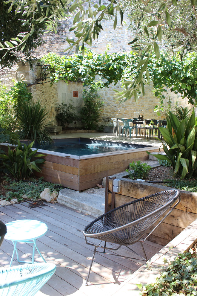 This is an example of a mediterranean backyard rectangular lap pool in Marseille with decking.