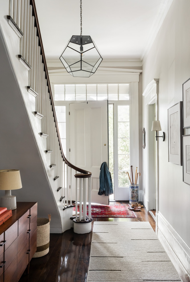 Inspiration for a medium sized traditional hallway in Boston with white walls, dark hardwood flooring, a single front door, a white front door and brown floors.