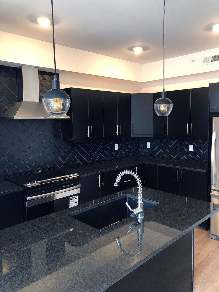 Mid-sized modern l-shaped open plan kitchen in Ottawa with a drop-in sink, flat-panel cabinets, black cabinets, marble benchtops, black splashback, ceramic splashback, stainless steel appliances, with island and multi-coloured benchtop.