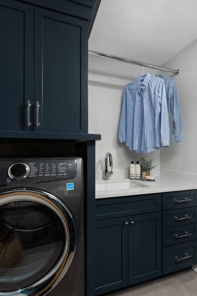 Inspiration for a transitional laundry room in Chicago with an undermount sink, shaker cabinets, grey walls, grey floor and white benchtop.