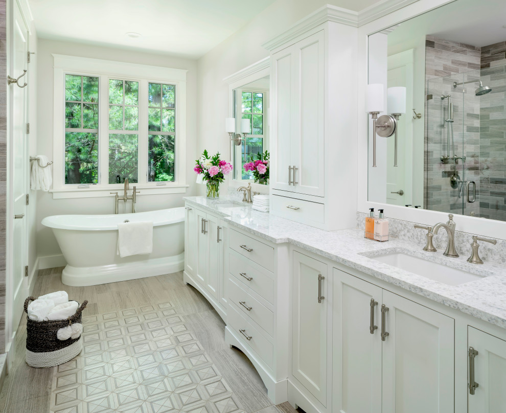 Inspiration for a large transitional master bathroom in Detroit with a double vanity, a built-in vanity, shaker cabinets, white cabinets, a freestanding tub, an alcove shower, multi-coloured tile, wood-look tile, white walls, an undermount sink, a hinged shower door, grey benchtops, a two-piece toilet, porcelain floors, engineered quartz benchtops and grey floor.