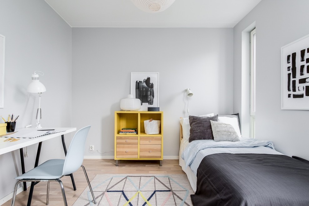 Photo of a mid-sized scandinavian gender-neutral kids' room in Stockholm with grey walls, light hardwood floors and beige floor.