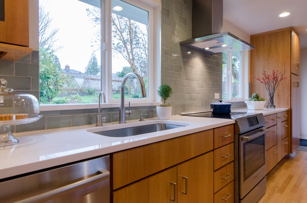 Inspiration for a mid-sized transitional l-shaped light wood floor kitchen remodel in Seattle with an undermount sink, flat-panel cabinets, medium tone wood cabinets, ceramic backsplash, stainless steel appliances and an island