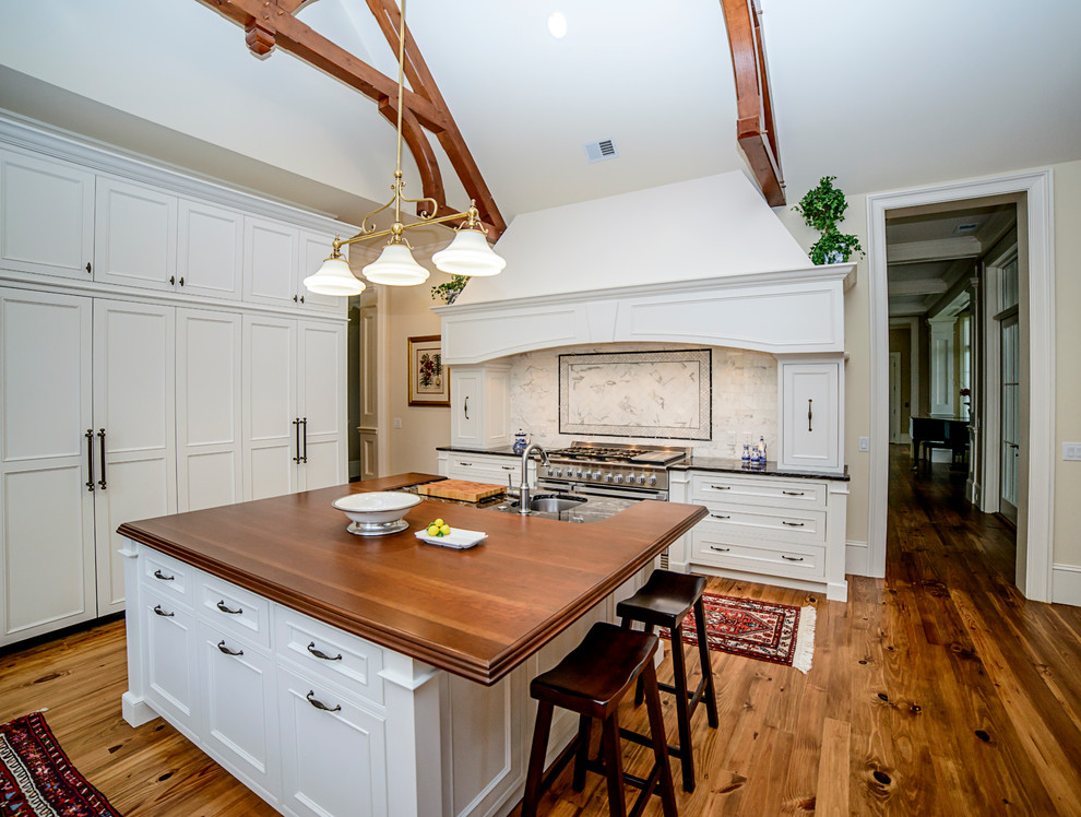Kitchen - transitional medium tone wood floor kitchen idea in Atlanta with an undermount sink, granite countertops, white backsplash, stainless steel appliances and an island