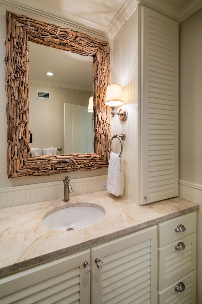 Beach style bathroom in Austin with an undermount sink and louvered cabinets.