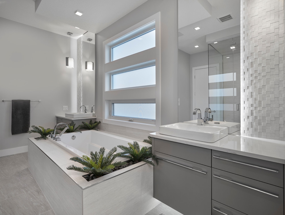 Design ideas for a contemporary bathroom in Edmonton with flat-panel cabinets, grey cabinets, a drop-in tub, a double shower, gray tile, porcelain tile, orange walls, porcelain floors, a vessel sink and quartzite benchtops.