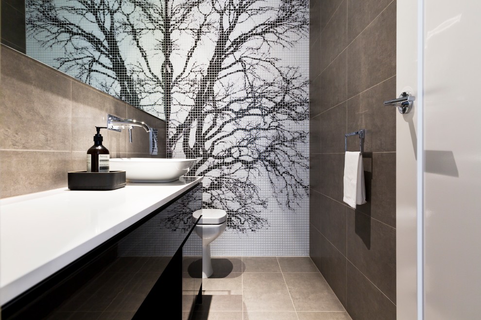 Photo of a modern powder room in Melbourne with flat-panel cabinets, beige tile, a vessel sink and beige floor.