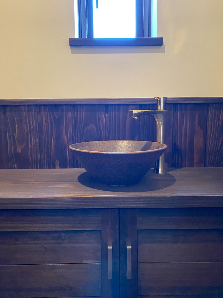 This is an example of a mid-sized traditional powder room in Other with furniture-like cabinets, brown cabinets, white walls, dark hardwood floors, a vessel sink, copper benchtops, brown floor, brown benchtops and a built-in vanity.