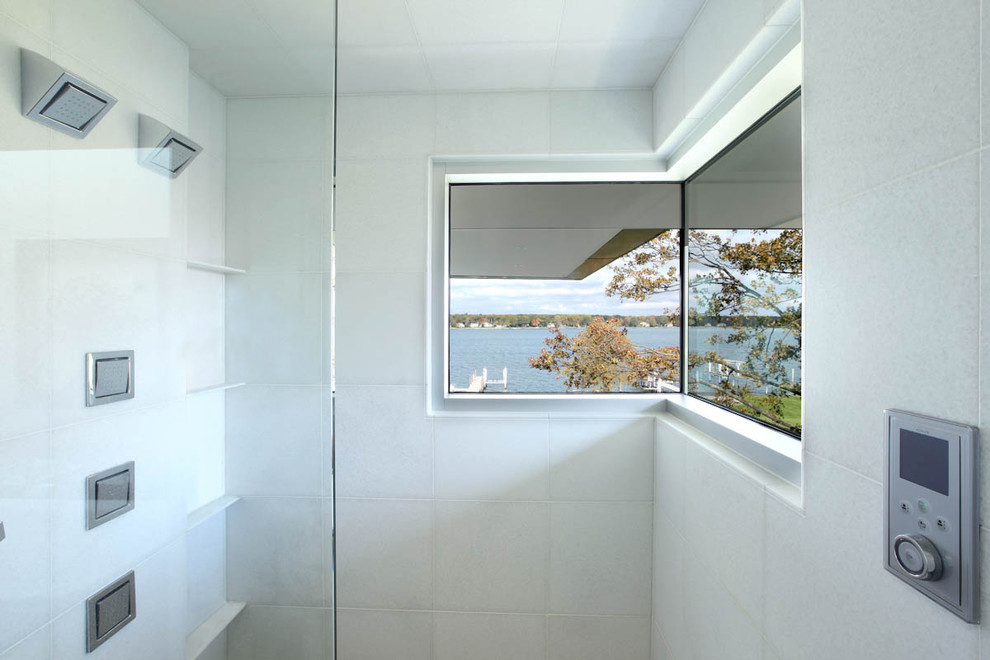 Contemporary master bathroom in Grand Rapids with an undermount sink, flat-panel cabinets, white cabinets, solid surface benchtops, a freestanding tub, a corner shower, a two-piece toilet, brown tile and white walls.