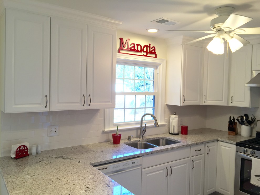 Inspiration for a mid-sized transitional u-shaped porcelain tile enclosed kitchen remodel with an undermount sink, raised-panel cabinets, white cabinets, granite countertops, white backsplash, ceramic backsplash, stainless steel appliances and a peninsula