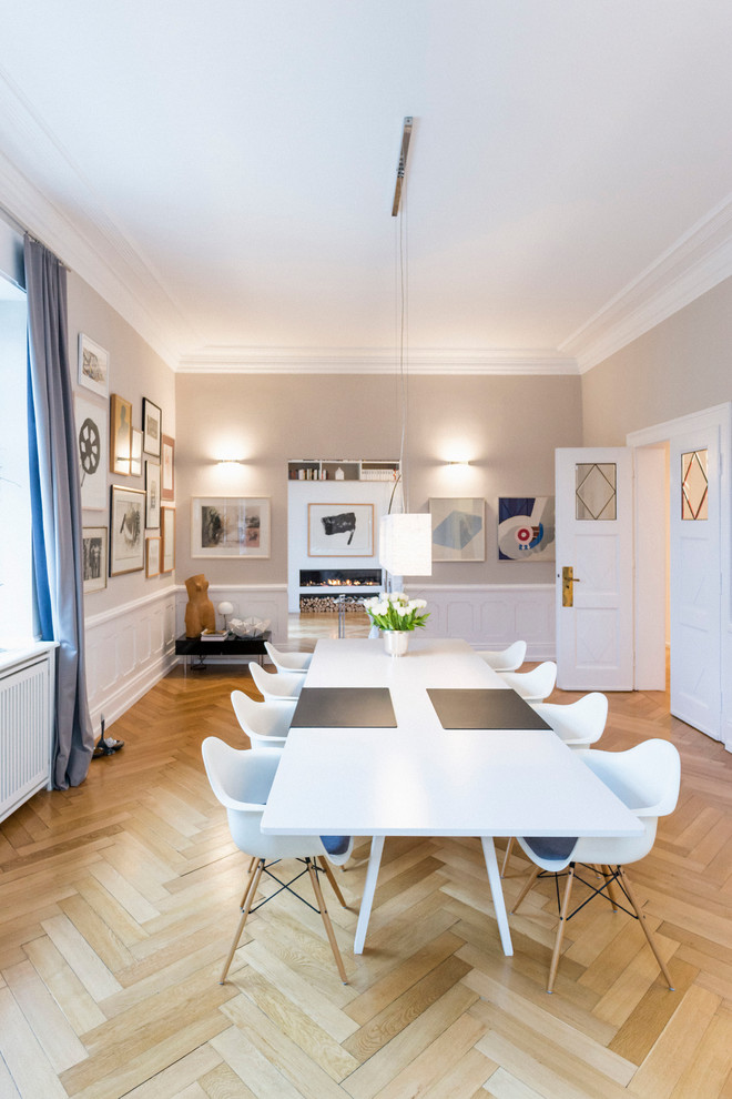 Design ideas for a large transitional separate dining room in Berlin with beige walls and light hardwood floors.