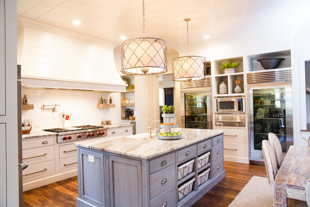 Design ideas for a country u-shaped kitchen in Atlanta with a farmhouse sink, beaded inset cabinets, white cabinets, white splashback, stainless steel appliances, medium hardwood floors and with island.
