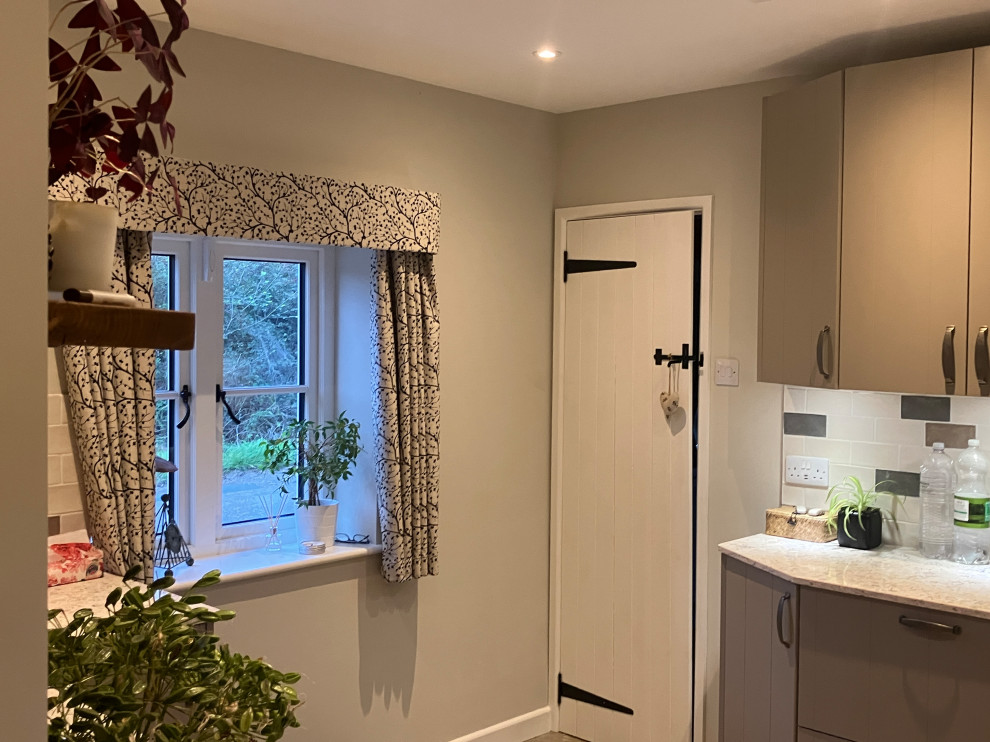 Design ideas for a mid-sized transitional u-shaped utility room in Dorset with a farmhouse sink, flat-panel cabinets, beige cabinets, quartzite benchtops, multi-coloured splashback, ceramic splashback, beige walls, ceramic floors, an integrated washer and dryer, multi-coloured floor and multi-coloured benchtop.