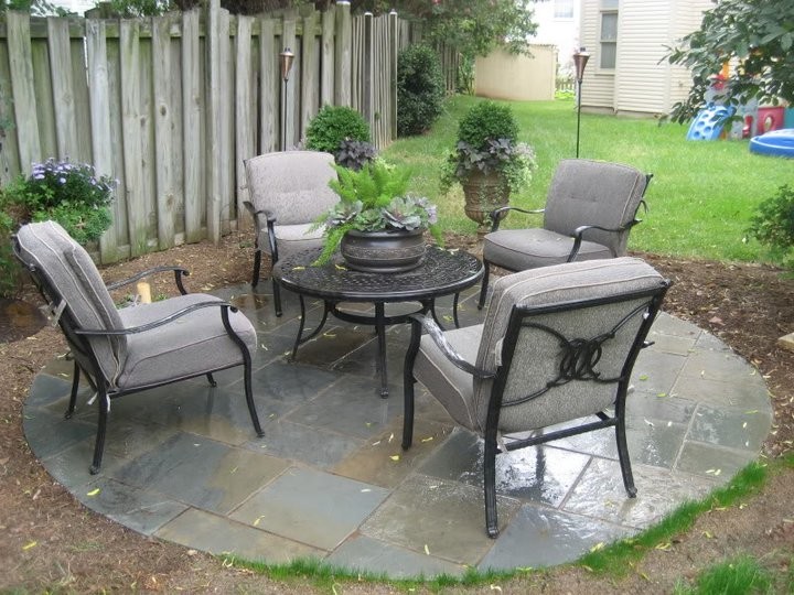 This is an example of a mid-sized traditional backyard patio in DC Metro with tile and no cover.
