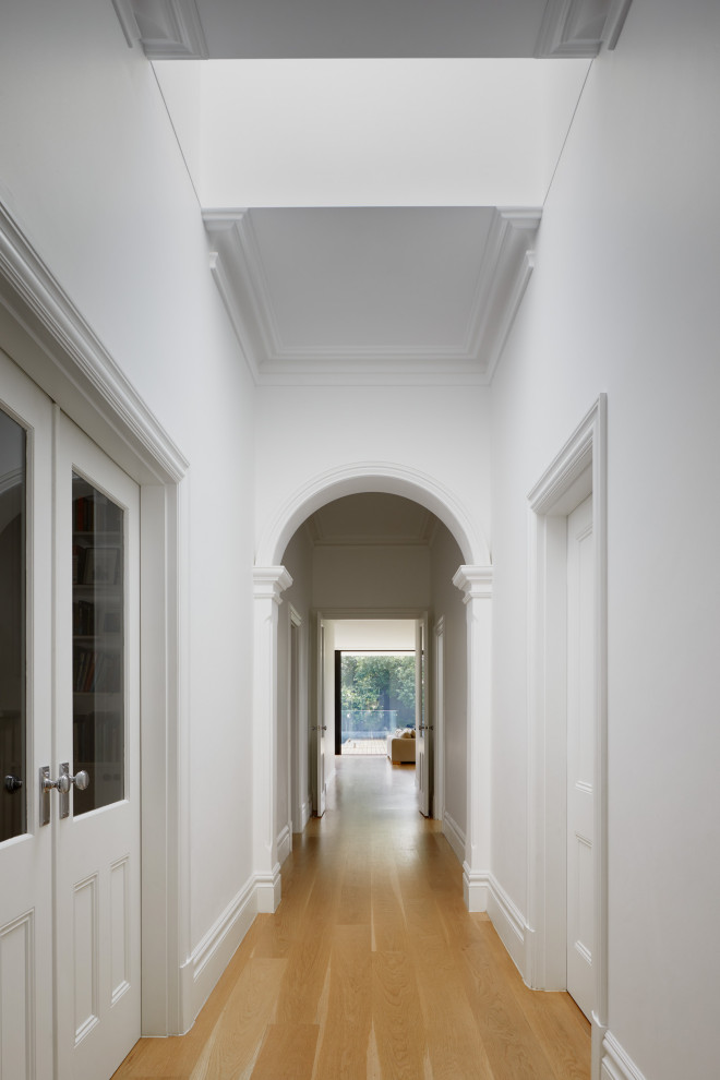 Idee per un ingresso o corridoio contemporaneo con pareti bianche e parquet chiaro