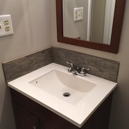 This is an example of a small modern 3/4 bathroom in Baltimore with flat-panel cabinets, dark wood cabinets, beige walls, a corner tub, an open shower, a one-piece toilet, white tile, stone slab, dark hardwood floors, a drop-in sink and solid surface benchtops.