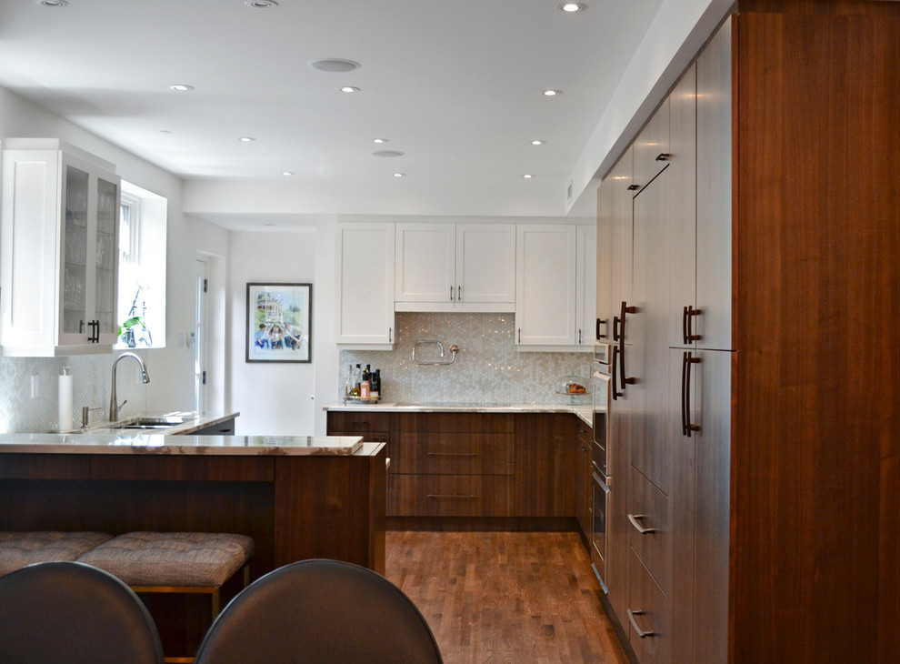 Example of a mid-sized transitional l-shaped dark wood floor eat-in kitchen design in Orange County with a double-bowl sink, shaker cabinets, white cabinets, granite countertops, gray backsplash, mosaic tile backsplash, paneled appliances and a peninsula