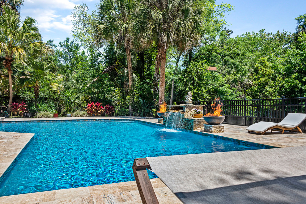 Photo of a transitional backyard custom-shaped pool in Other with a water feature.