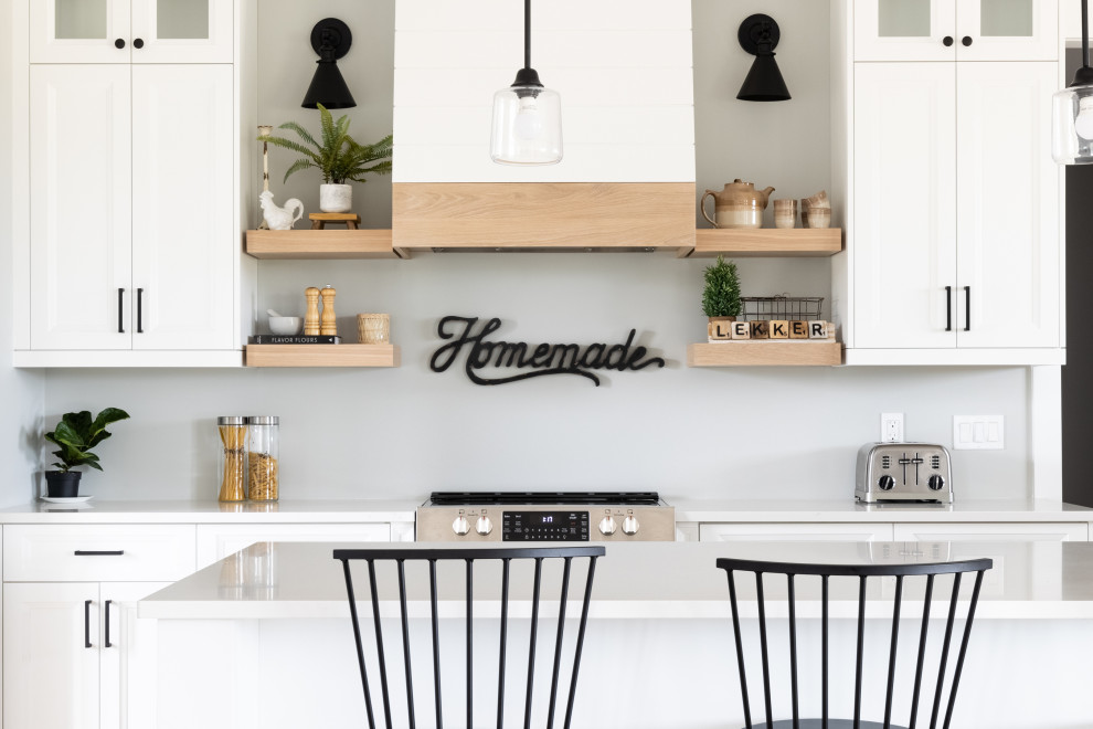 This is an example of a mid-sized transitional l-shaped eat-in kitchen in Other with an undermount sink, shaker cabinets, white cabinets, quartz benchtops, shiplap splashback, stainless steel appliances, medium hardwood floors, with island, multi-coloured floor, white benchtop and vaulted.