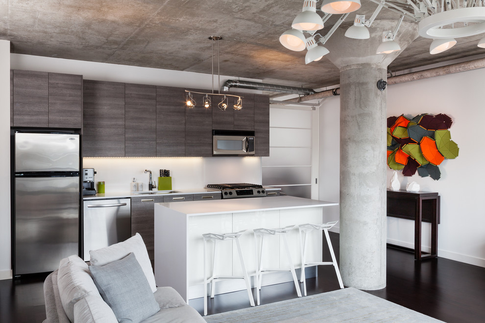 Mid-sized modern single-wall open plan kitchen in Toronto with an undermount sink, grey cabinets, white splashback, stainless steel appliances, flat-panel cabinets, quartz benchtops and dark hardwood floors.