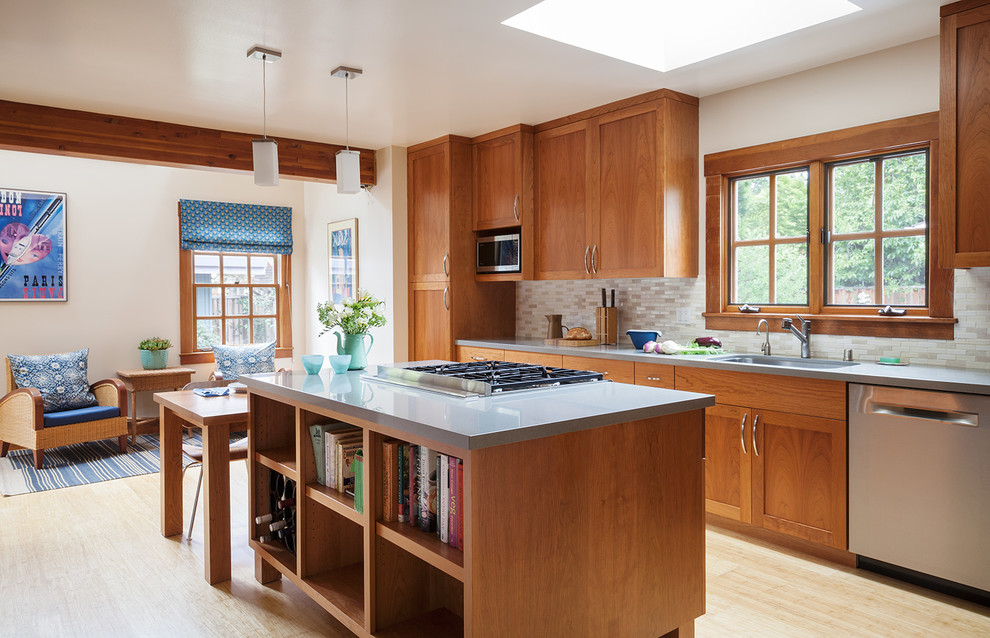 Photo of a mid-sized transitional u-shaped eat-in kitchen in San Francisco with a single-bowl sink, shaker cabinets, medium wood cabinets, quartz benchtops, beige splashback, ceramic splashback, stainless steel appliances, with island, bamboo floors and beige floor.