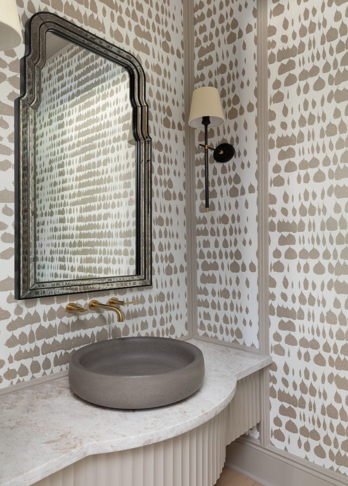 Bild på ett vintage vit vitt toalett, med beige skåp, beige väggar, mellanmörkt trägolv, ett fristående handfat och brunt golv